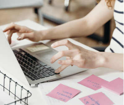 agency worker using post-it notes at her laptop