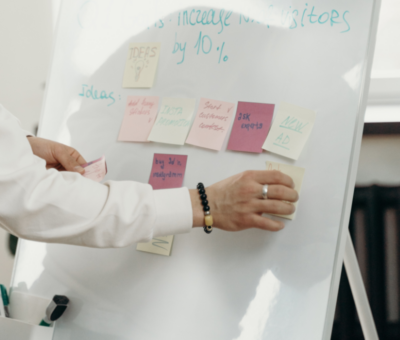 man using whiteboard with post it notes